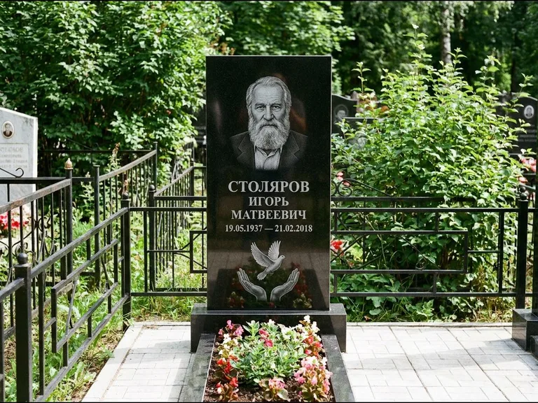 Памятник с гравировкой голубей — гравировка голубя над раскрытыми ладонями внизу стелы, работа «Столяров» в Новом Уренгое