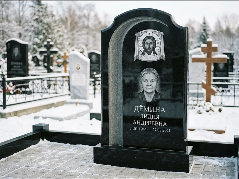 Памятник с гравировкой иконы: гранёный восьмиугольный обелиск с крестом — гравировка Николая Чудотворца, семейный участок с гранитной скамьёй, работа «Зотов» в Новом Уренгое