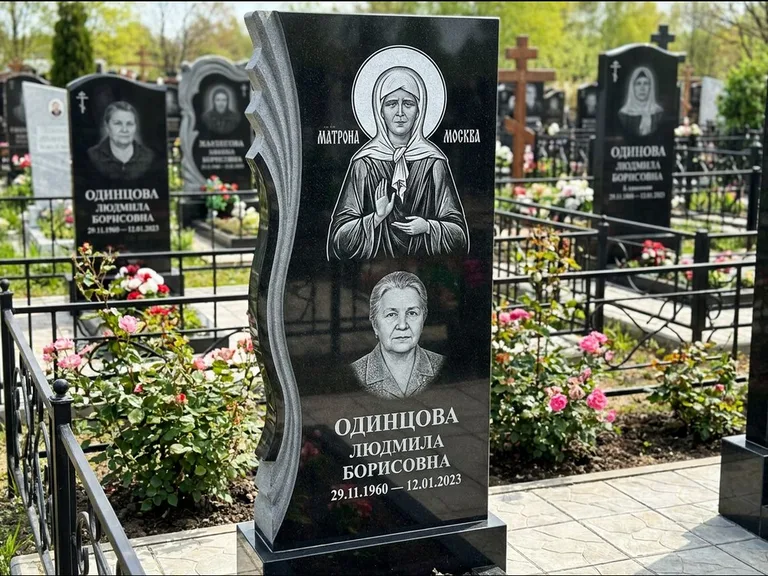Памятник с гравировкой иконы: ступенчатая двухуровневая стела — Архангел Михаил на стеле, каменная дорожка из плитняка, работа «Одинцов» в Новом Уренгое