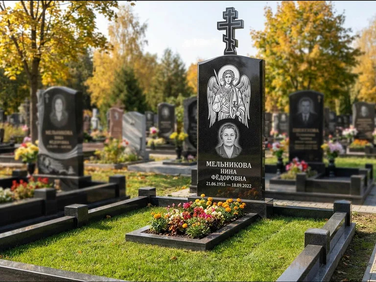 Памятник с гравировкой иконы: округлая стела-медальон с ликом — гравировка Богородицы «Семистрельная», луговые травы и полевые цветы за участком, работа «Гущин» в Новом Уренгое