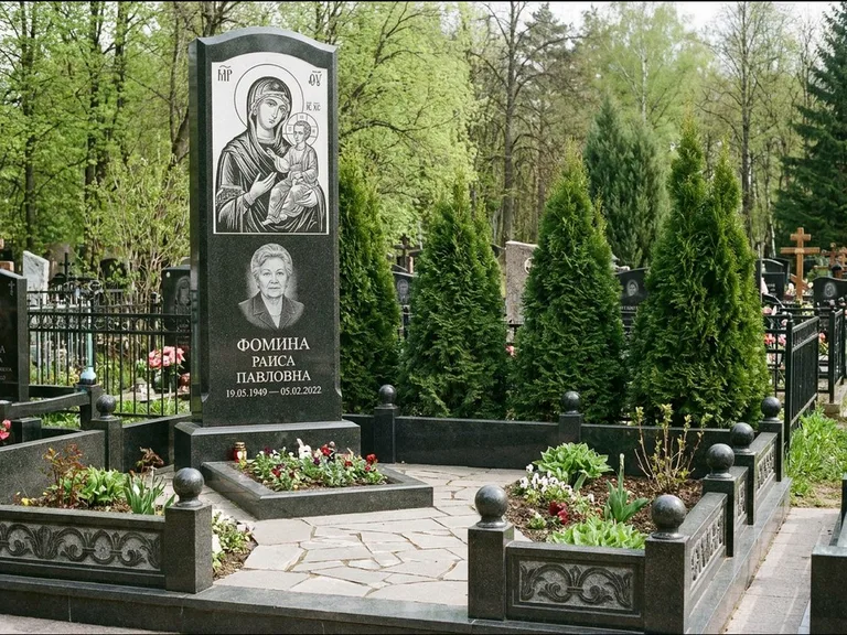 Памятник с гравировкой иконы: высокий гранёный обелиск с крестом-навершием — гравировка образа Матроны Московской, открытый участок без ограды, работа «Третьяков» в Новом Уренгое