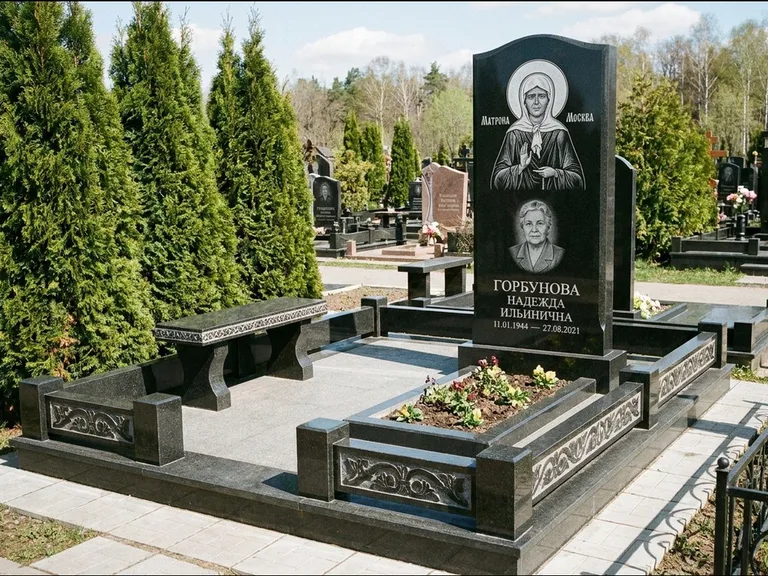 Памятник с гравировкой иконы: стела в форме раскрытой книги с образом — гравировка образа Спасителя, цоколь тёмной плиткой, работа «Зотов» в Новом Уренгое