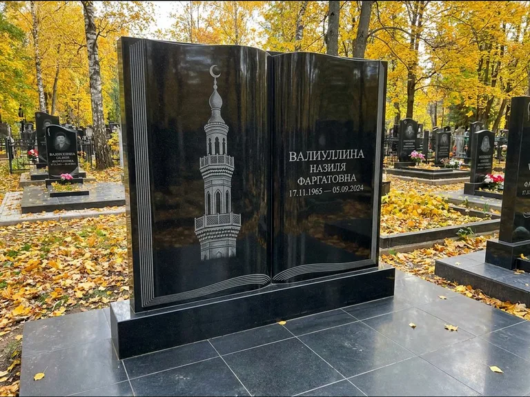 Мусульманский памятник с гравировкой мечети: стела в форме раскрытой книги на подставке — белая гравировка силуэта мечети с минаретами, цоколь тёмной плиткой, работа «Исмаилова» в Новом Уренгое