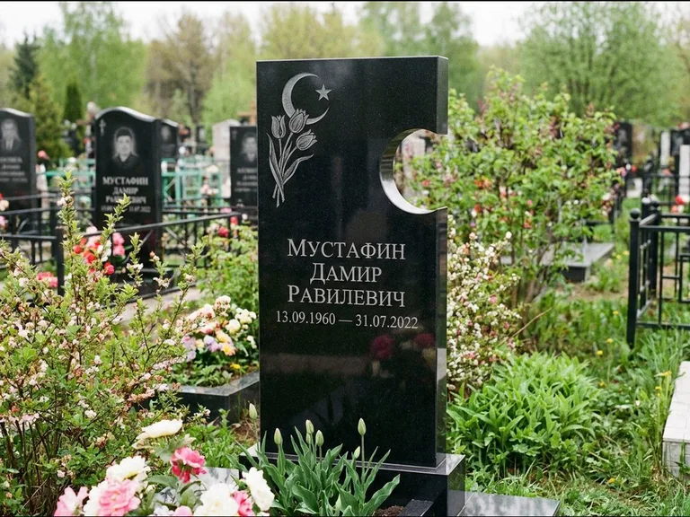Мусульманский памятник: стела с боковым вырезом в форме полумесяца — гравировка минарета с полумесяцем, низкие кусты в цвету, работа «Мустафин» в Новом Уренгое