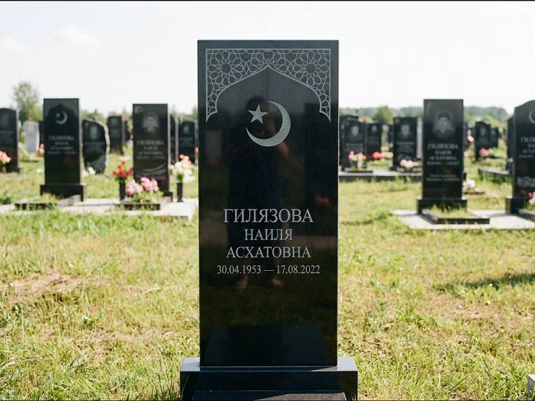 Мусульманский памятник: узкая вертикальная стела-пилон с полумесяцем — гравировка мечети в михраб-арке с орнаментом, открытая лужайка без ограды, работа «Ибрагимова» в Новом Уренгое