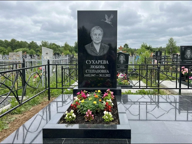 Памятник с гравировкой журавлей — гравировка одиночного летящего журавля над портретом, работа «Сухарева» в Новом Уренгое