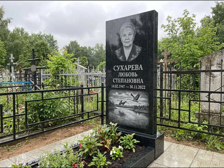 Памятник с гравировкой журавлей — гравировка пары журавлей над гладью озера в нижней части, работа «Сухарева» в Новом Уренгое